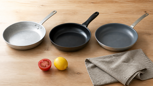Drei Pfannenbauweisen im Vergleich: blankes Aluminium, beschichteter Aluguss und eine 3-Ply-Pfanne mit Keramikbeschichtung